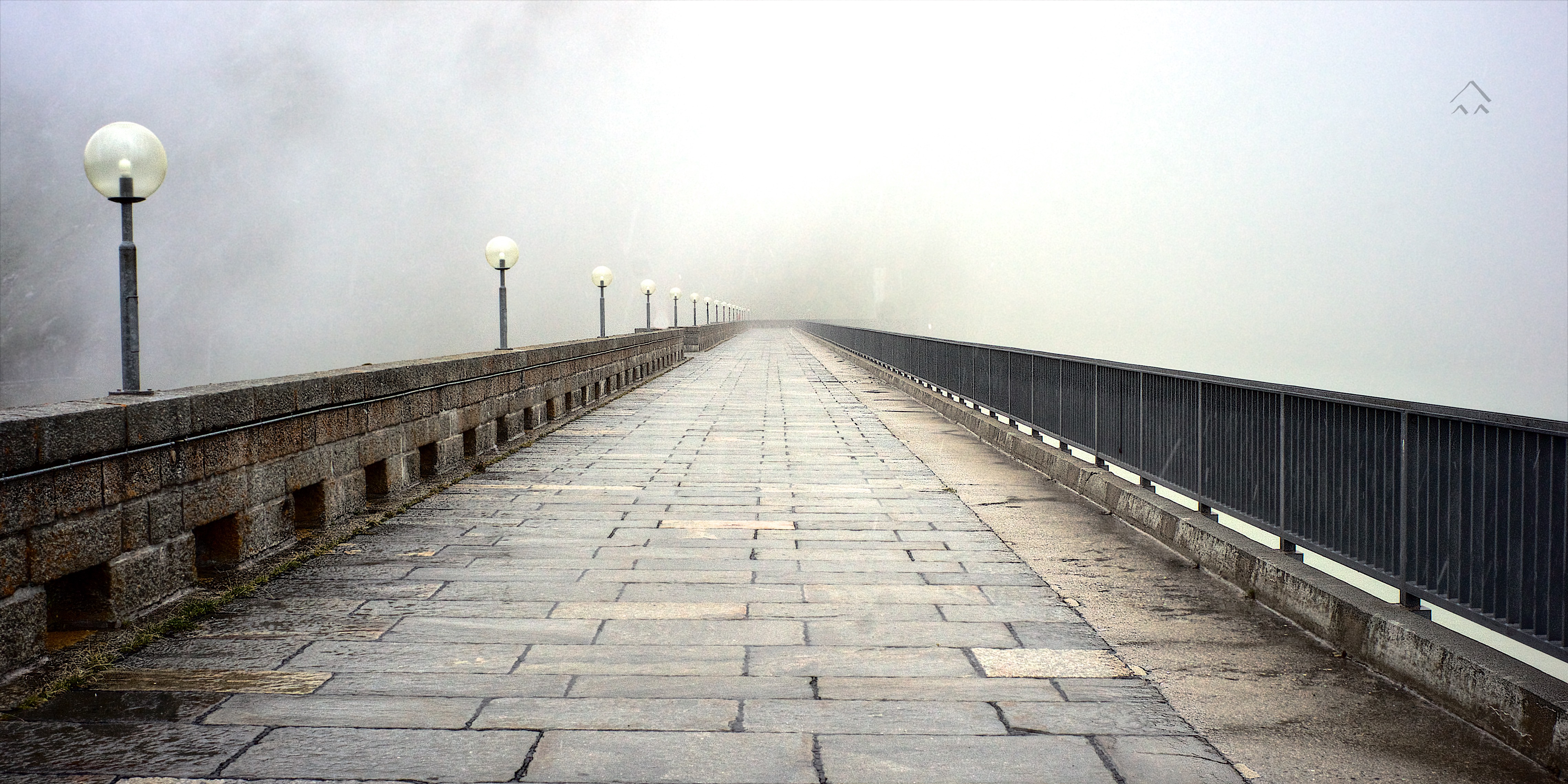 fog sourrounds the access route via a dam to the Grimsel Hospiz